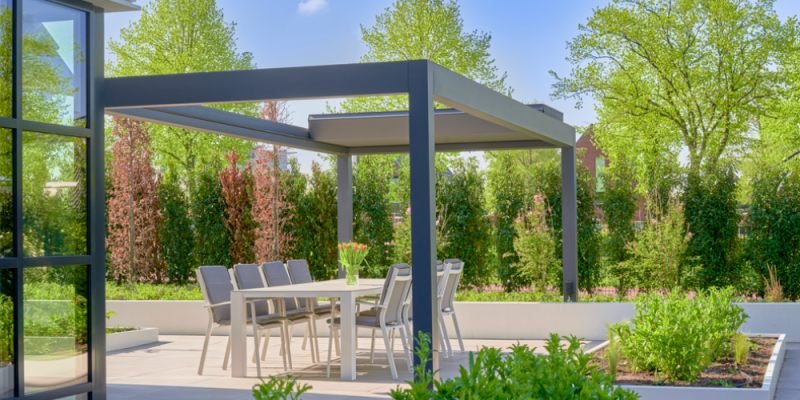 Freistehende bioklimatische Pergola in Anthrazit über einem Esstisch im Garten – Gesamtansicht